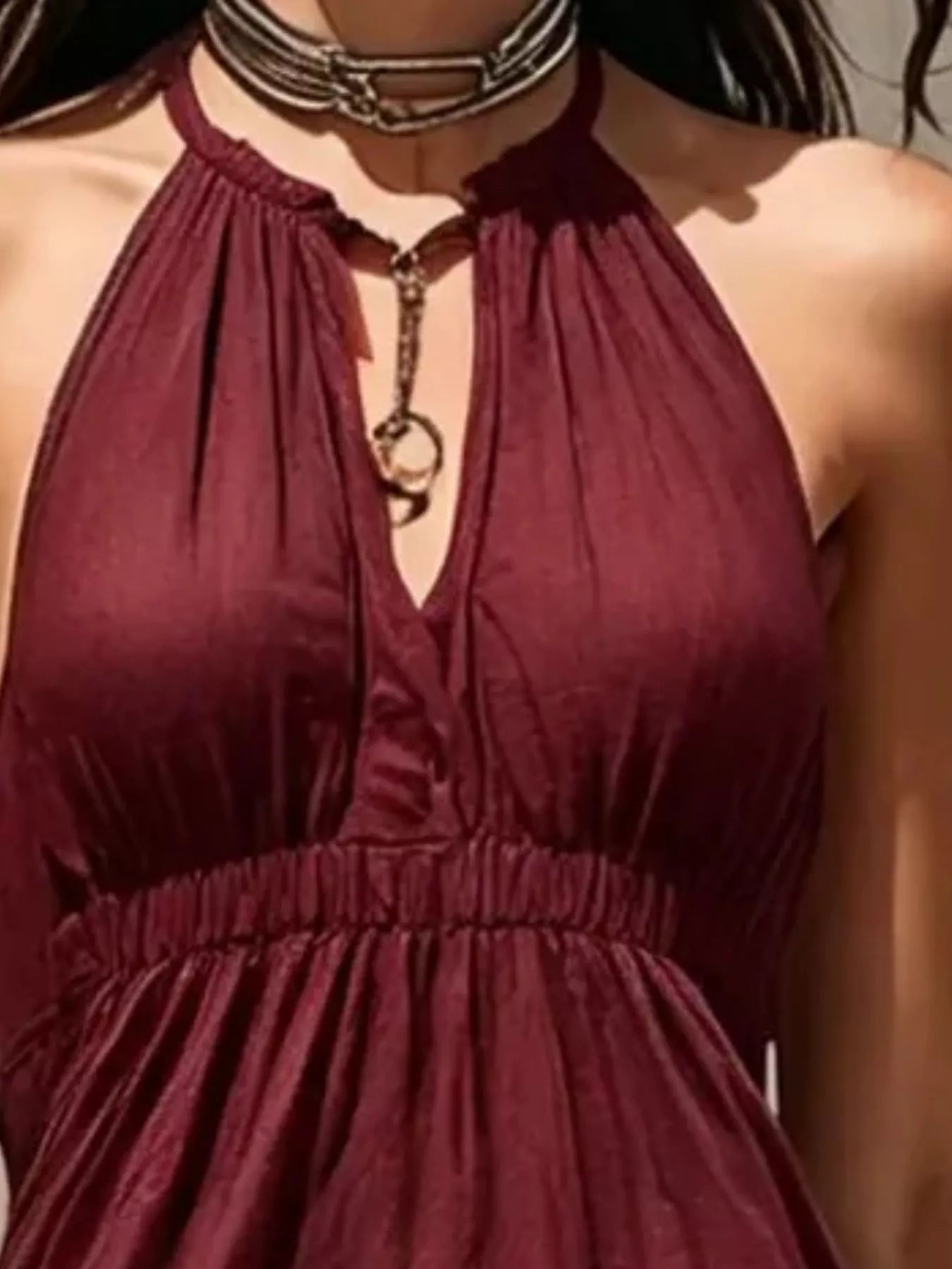 Close-up of burgundy halter dress with keyhole button detail and elastic waist.