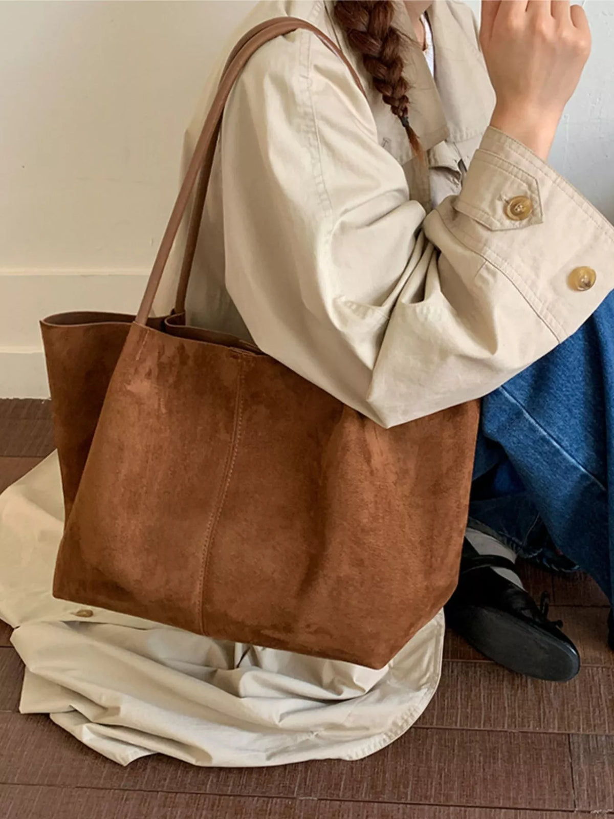 Brown suede large tote bag worn on shoulder with wide top handles