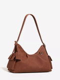 Brown suede ruched shoulder bag with top handle, side straps, and metal ring hardware