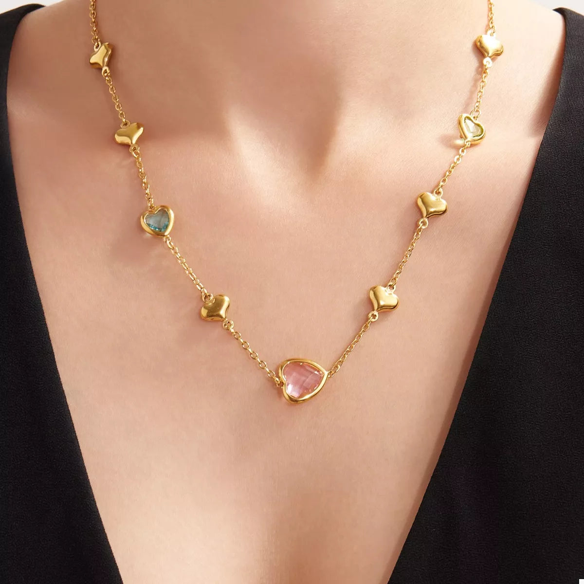 Gold-plated heart necklace with pink glass heart and small blue stone accents