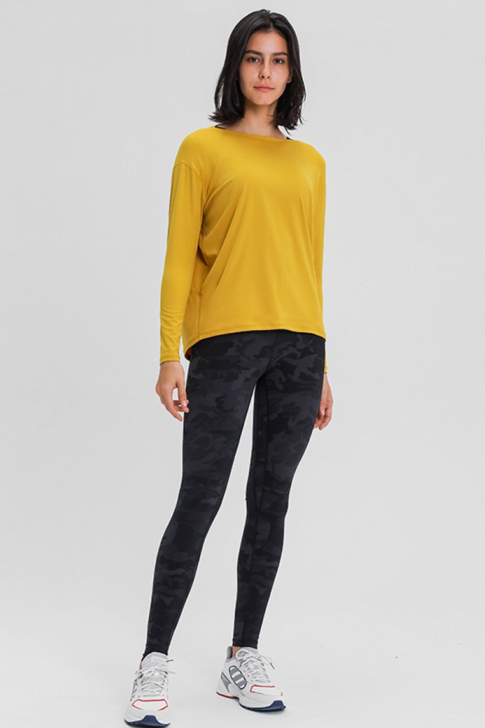 Loose-fit active top in mustard yellow with long sleeves and relaxed silhouette.