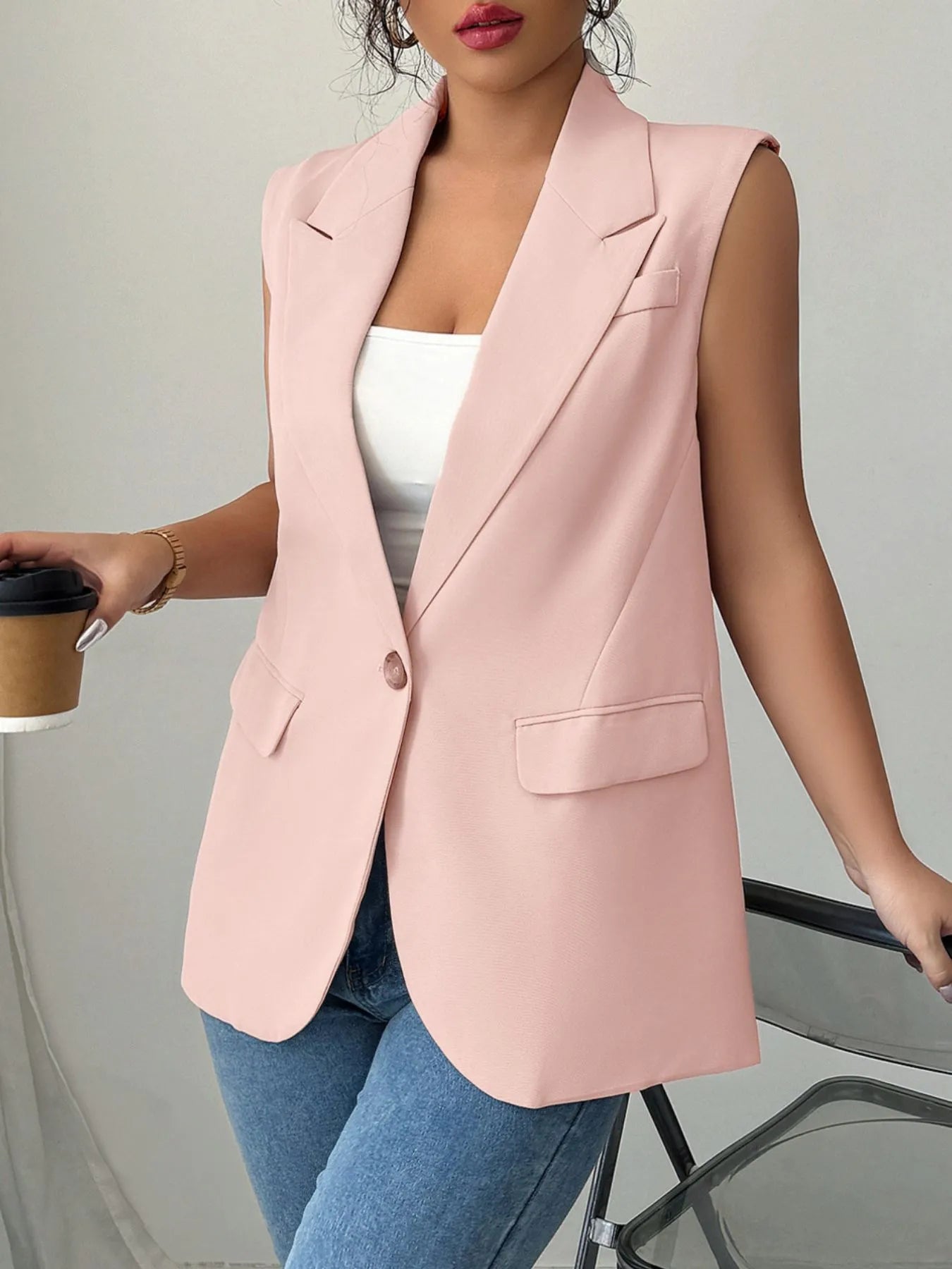 Pale blush sleeveless blazer with one button, notched lapels, and flap pockets