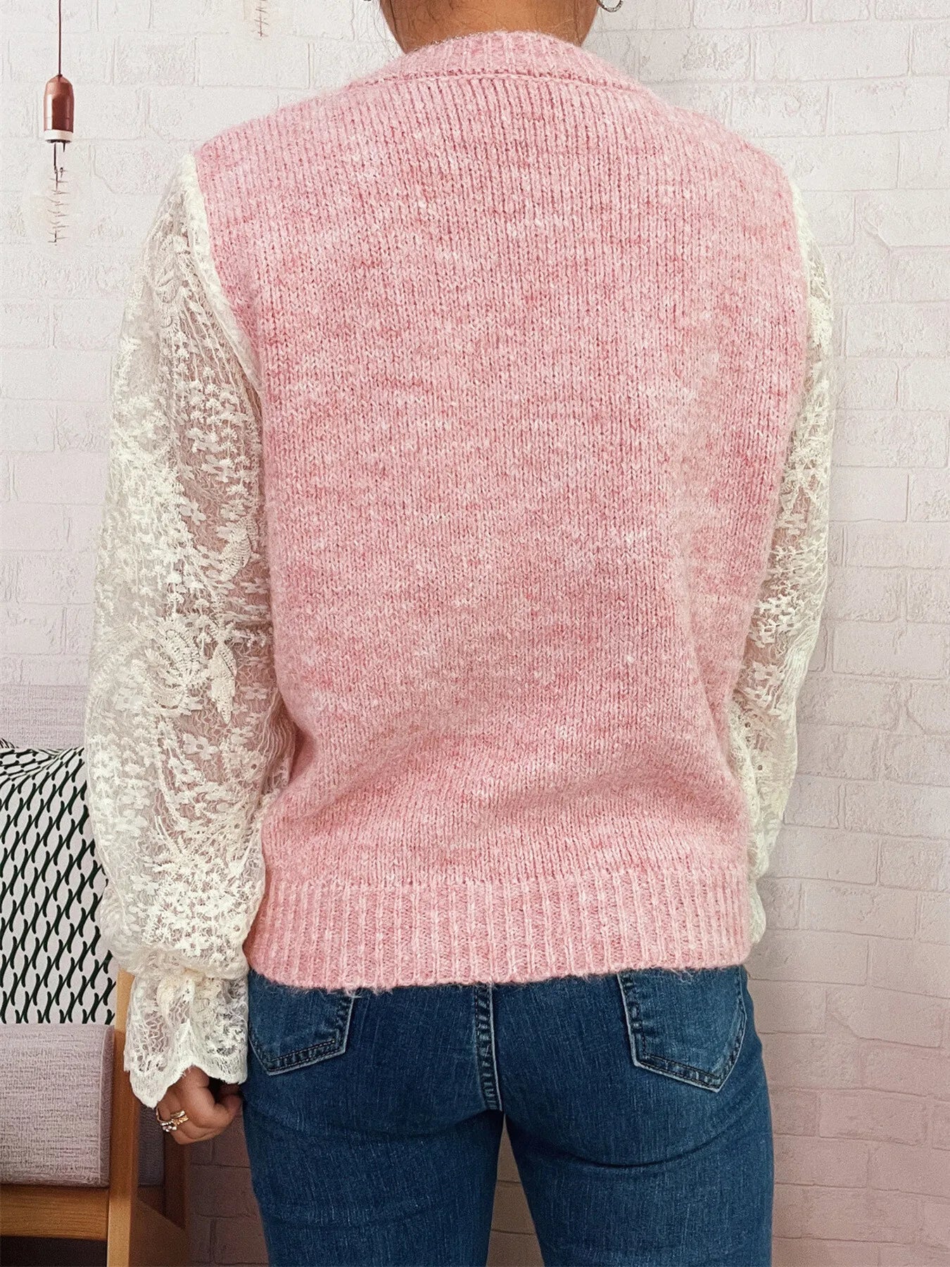 Pink knit button-up cardigan with lace sleeves, shown from back