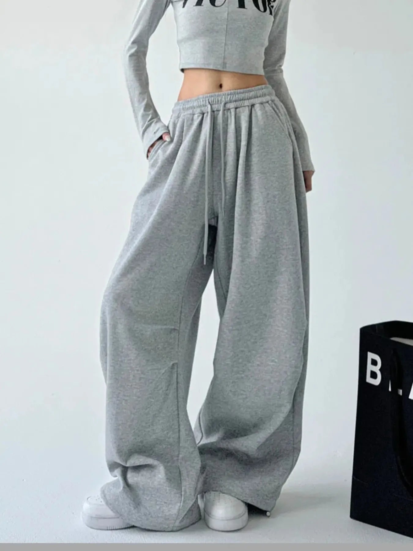Dark gray oversized wide-leg drawstring pants with elastic waistband and side pockets