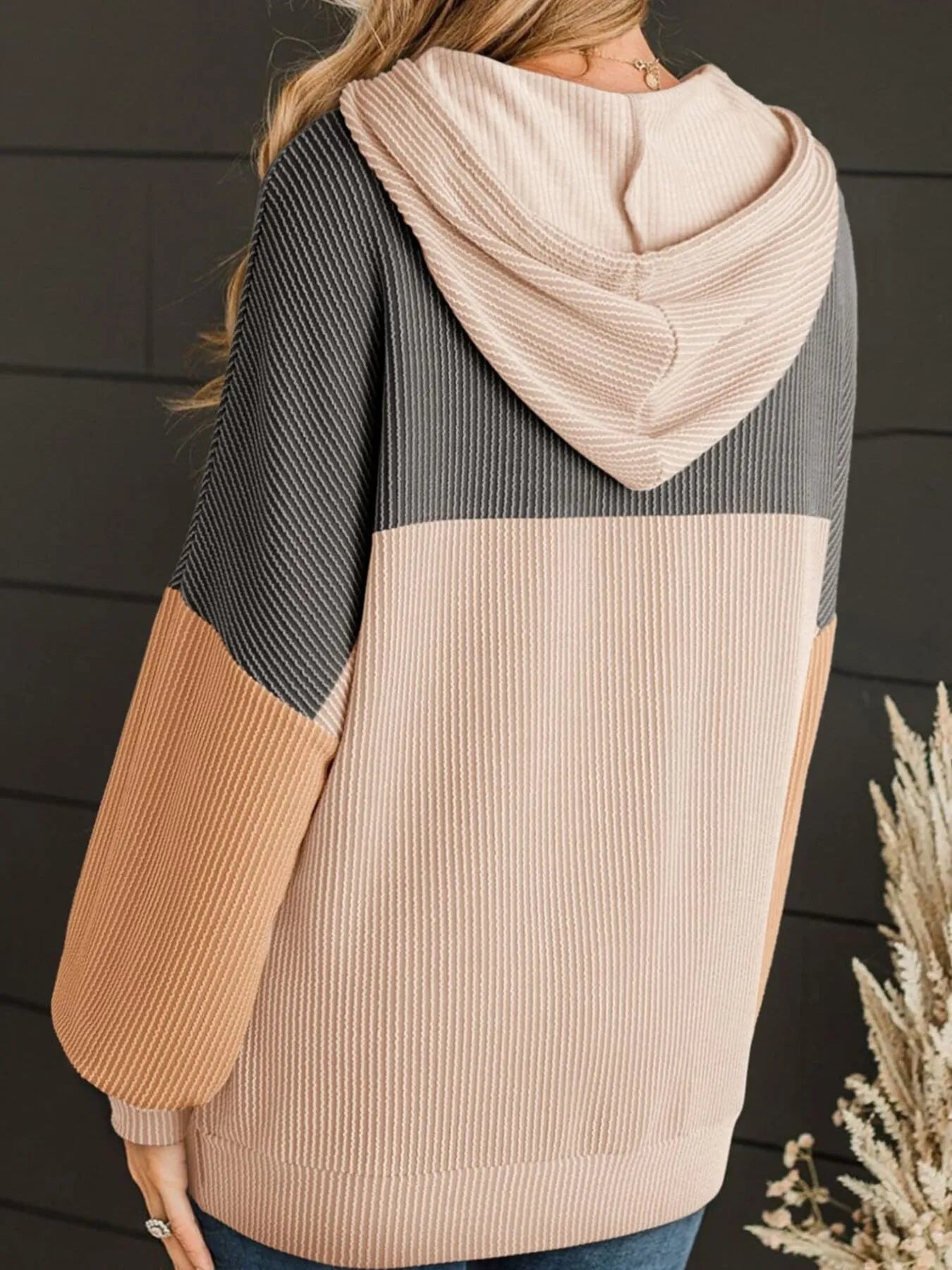 Color-block long-sleeve hoodie with hood and drawstring, dark charcoal back, cream panel, tan sleeves