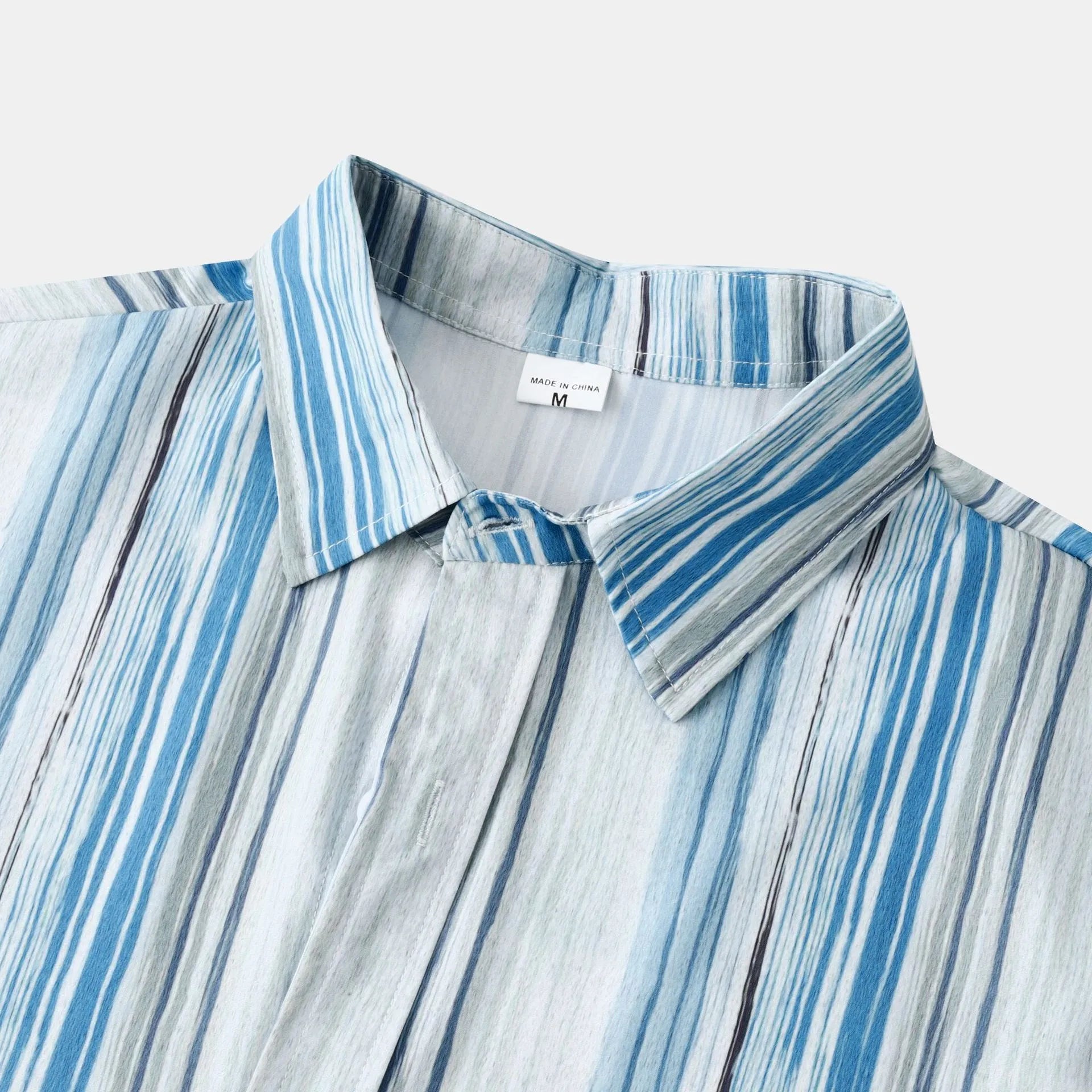 Button-up shirt collar with pastel blue stripe pattern on white base, long sleeves
