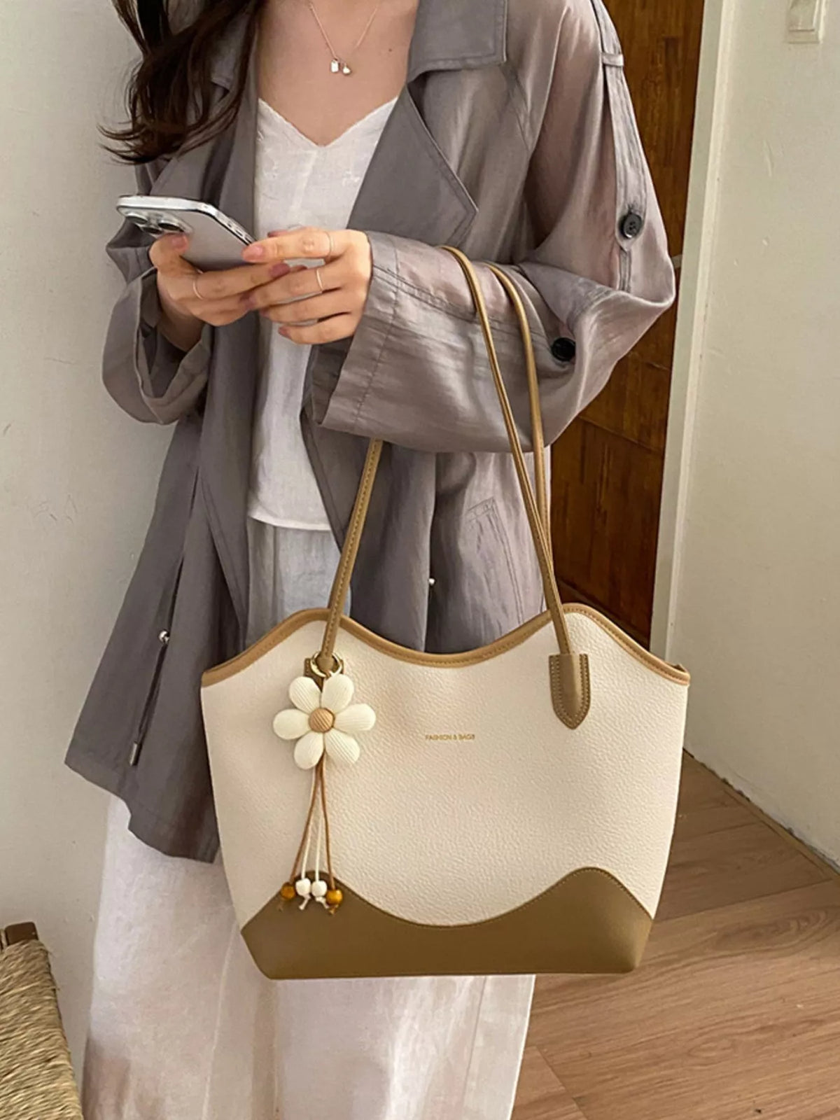 Vegan leather shoulder bag in cream and tan with daisy charm and top handles