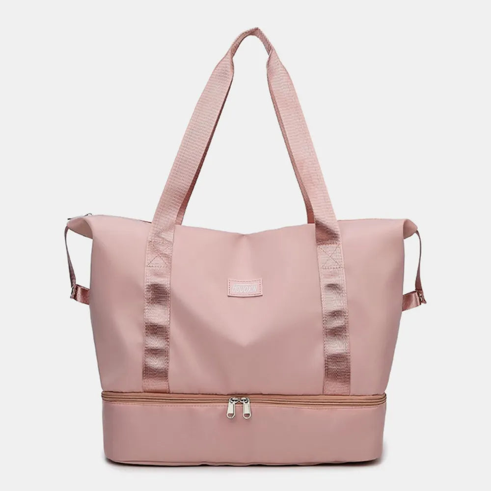 Pale blush pink nylon travel duffel bag with wide straps and front zip pocket.