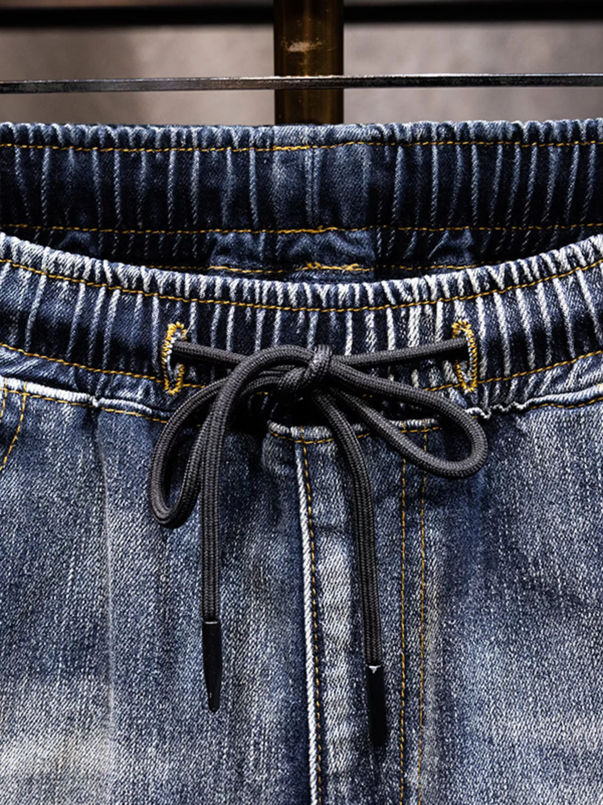 Men's cotton jeans waistband close-up with drawstring and elastic back