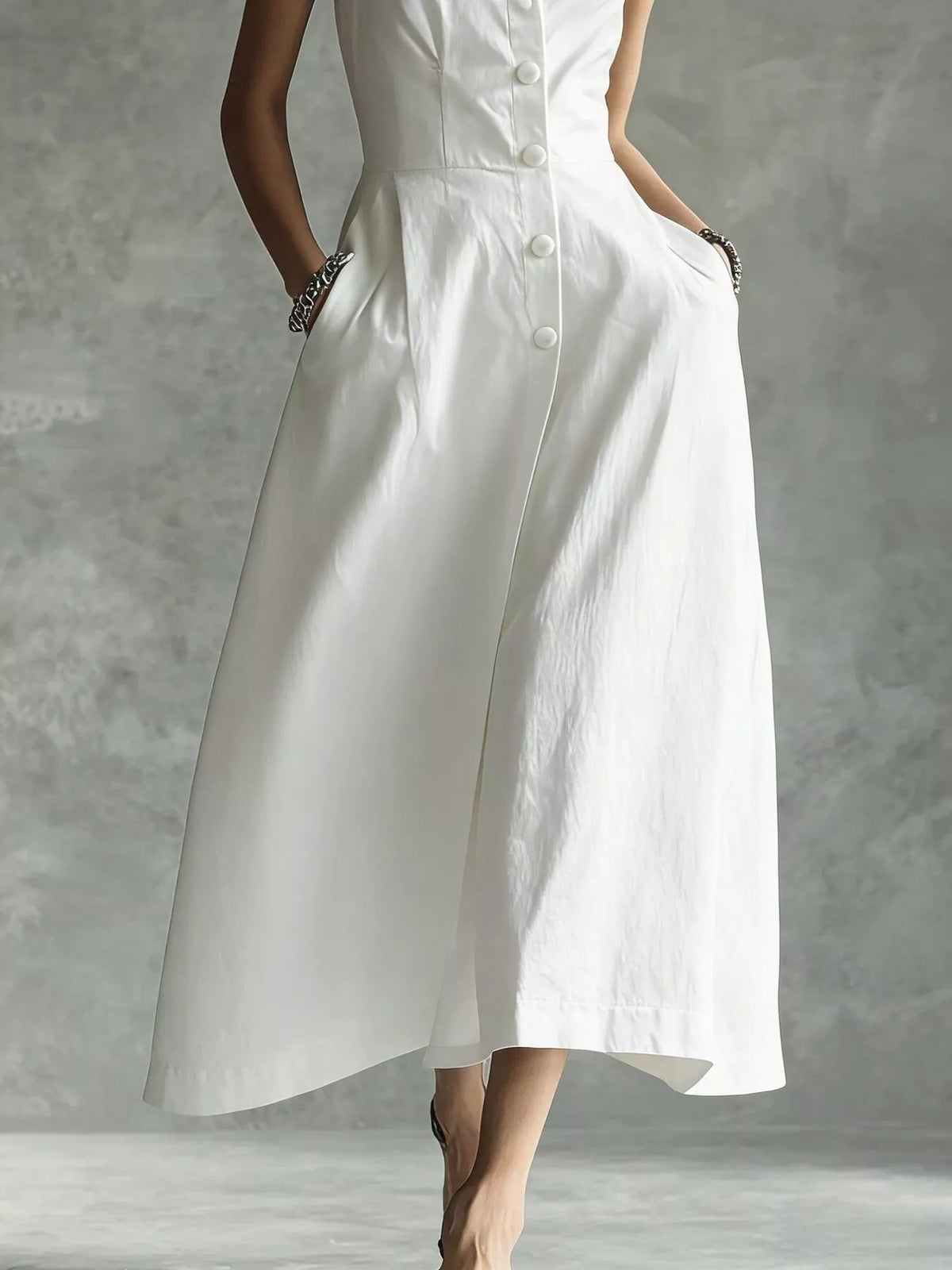 White sleeveless midi button shirt dress with pointed collar and wide flared skirt.