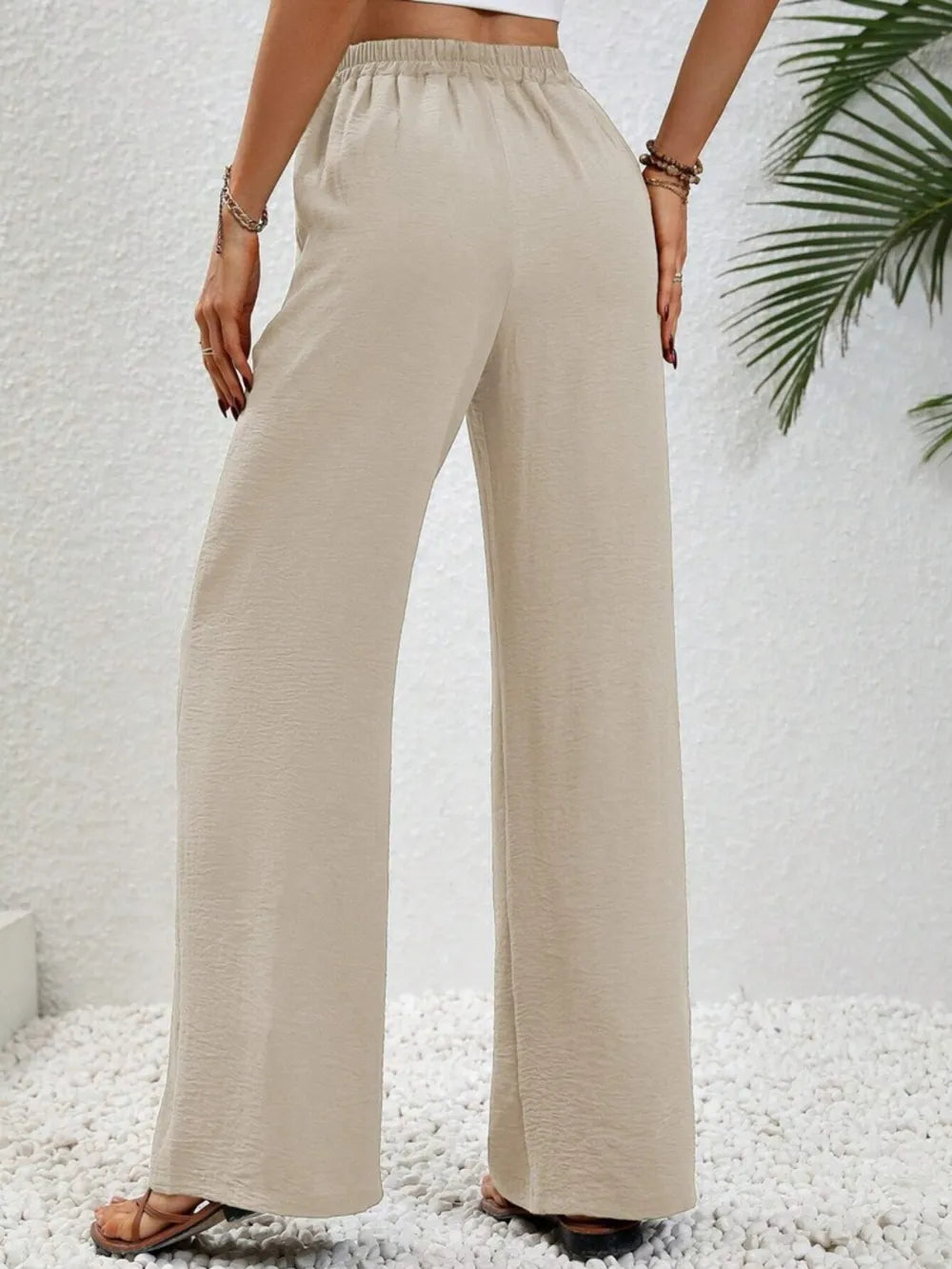 Cream wide-leg drawstring pants with elastic waist and relaxed straight legs