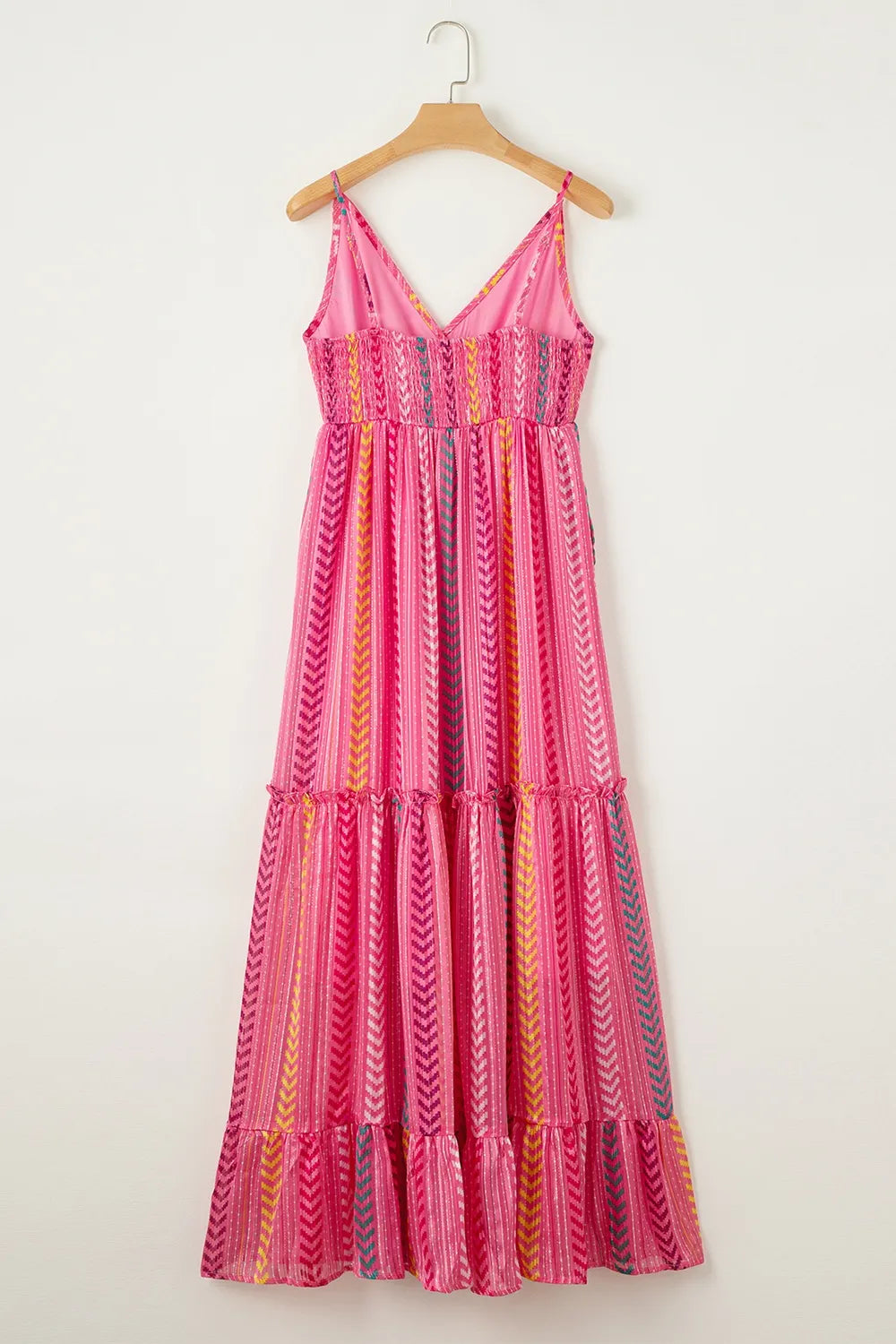 Pink printed maxi cami dress on hanger with crisscross back straps and tiered hem