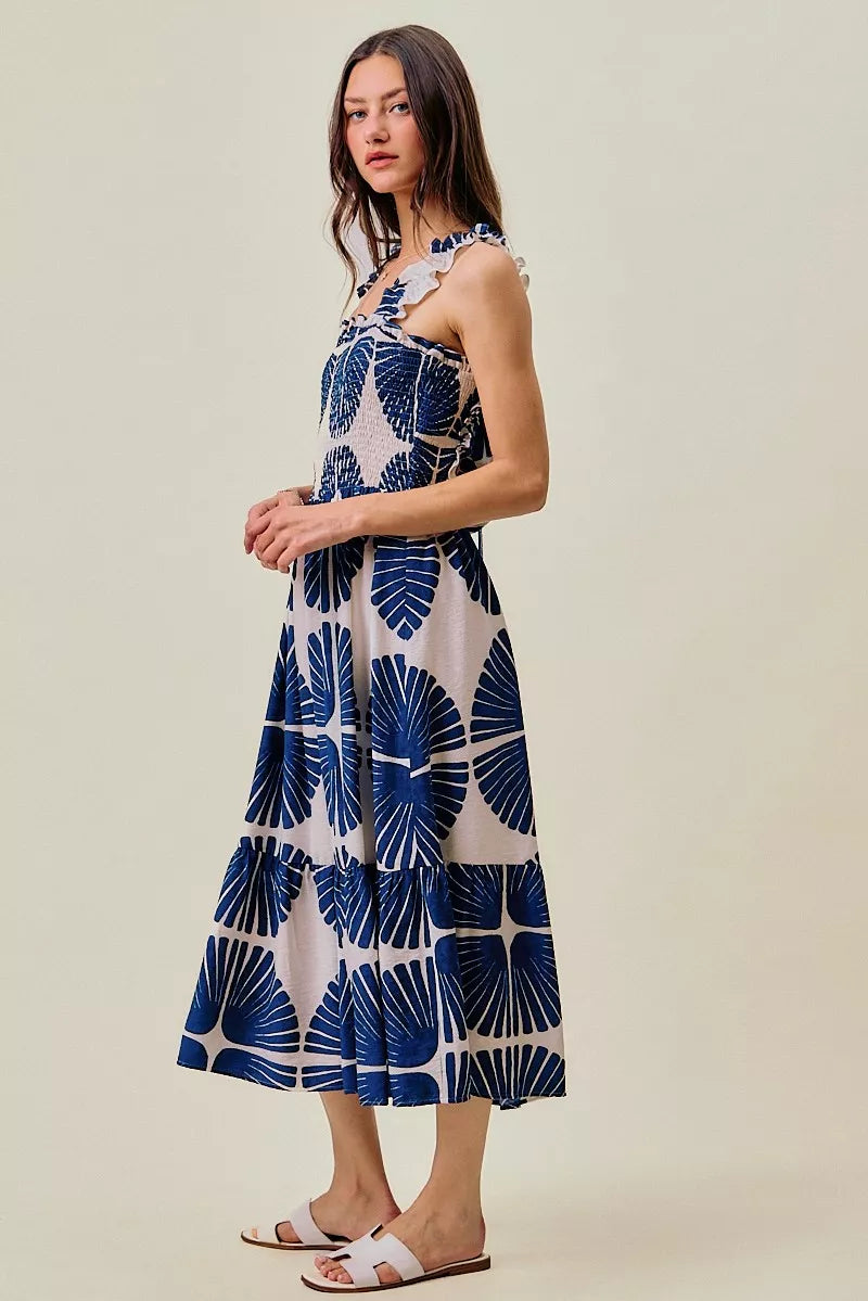 Front side view of navy and white abstract print tiered midi dress with ruffled straps