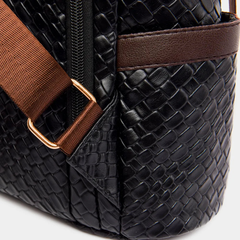 Vegan leather backpack bag close-up, embossed black texture with brown trim