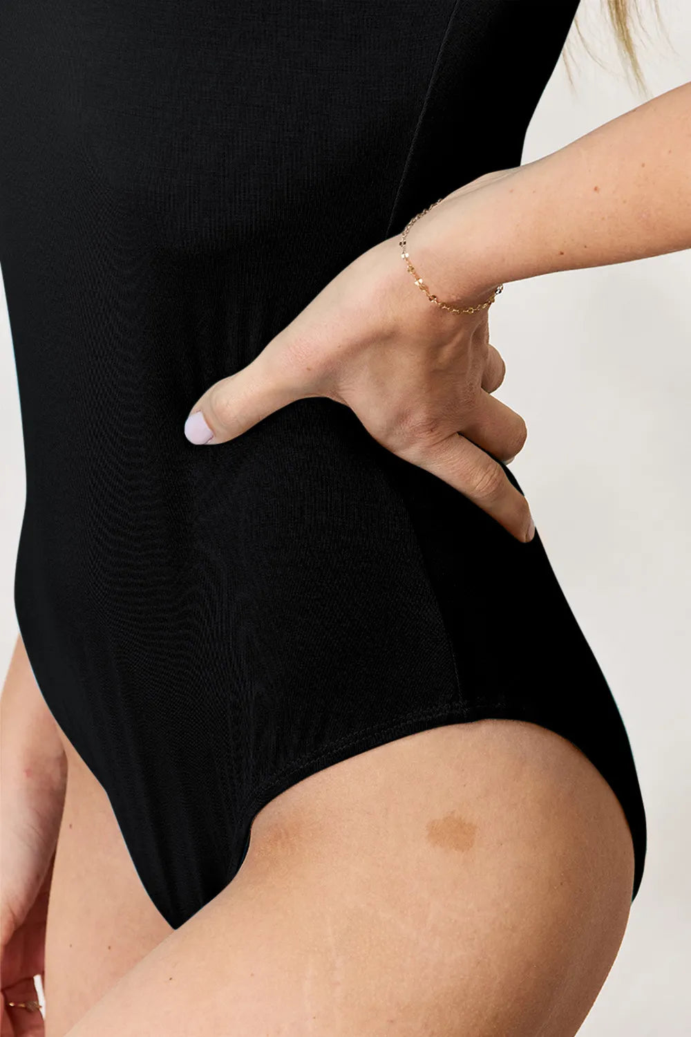 Black short-sleeve round-neck full-size bodysuit, hip and leg opening detail