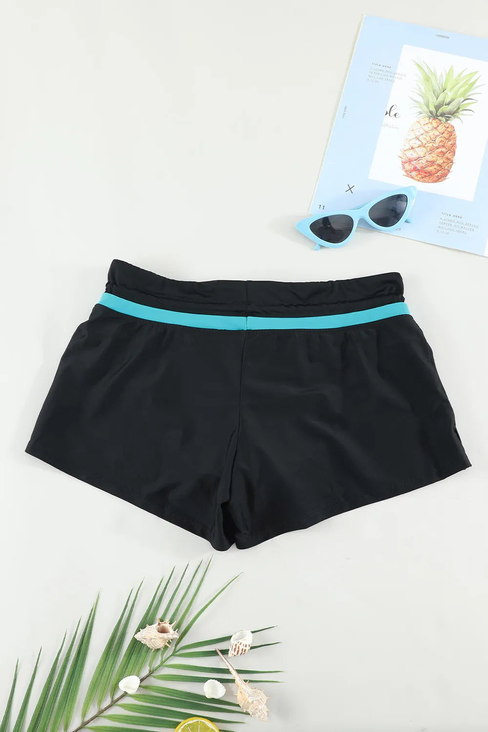 Black swim shorts with turquoise waistband trim, relaxed fit, front view