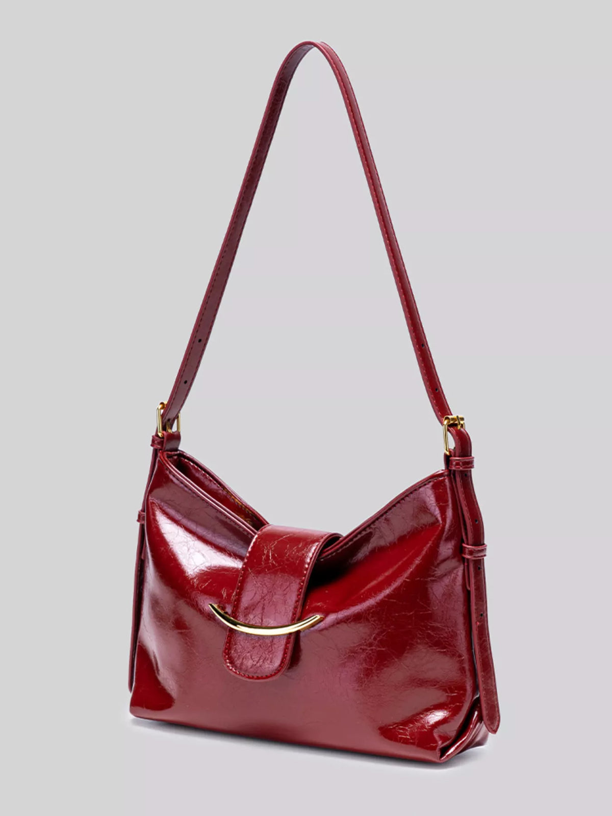 Wine red gloss vegan leather crescent shoulder bag with curved top and crossbody strap
