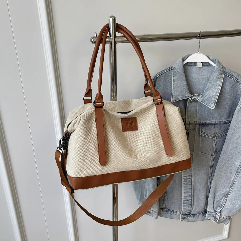 Large polyester duffle bag in cream with brown contrast handles and shoulder strap