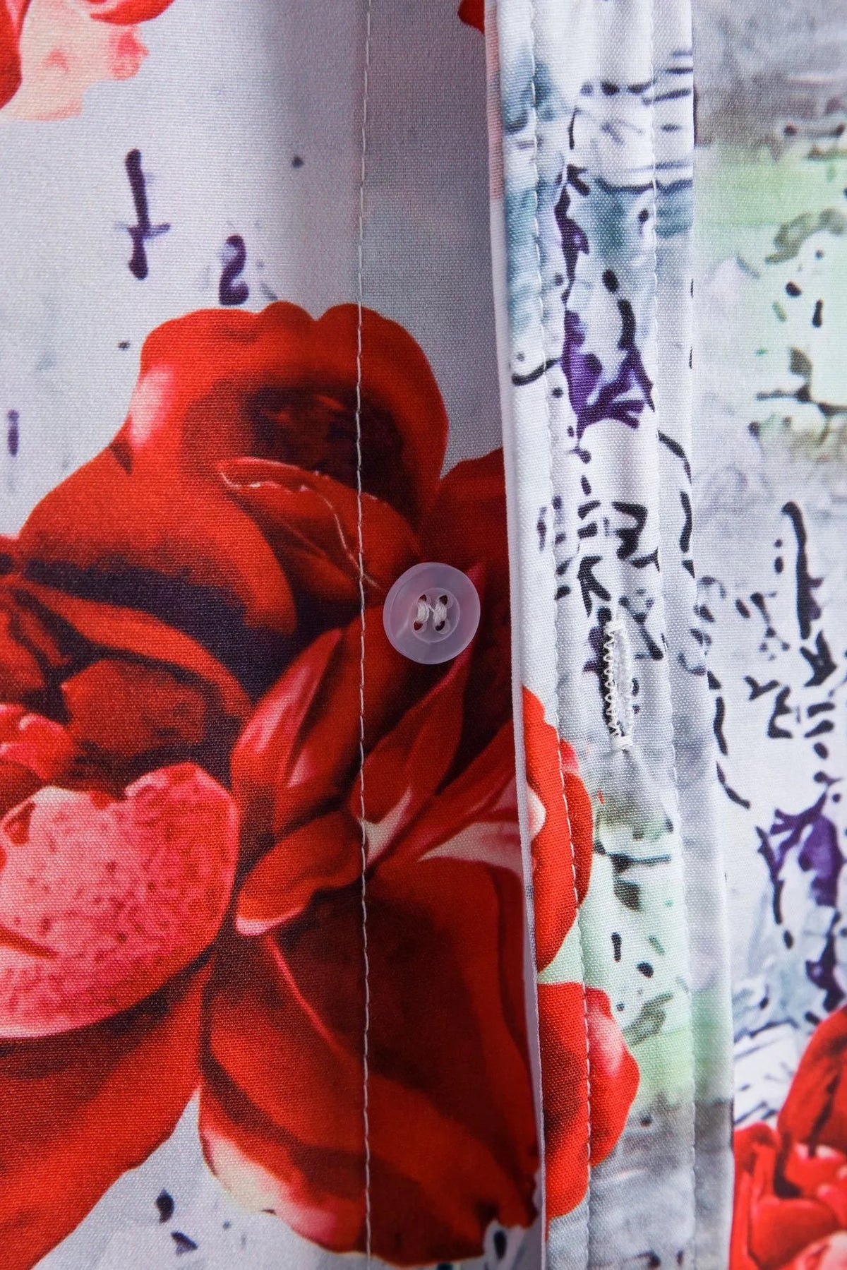 Floral button-up shirt side detail with button, red rose print on white
