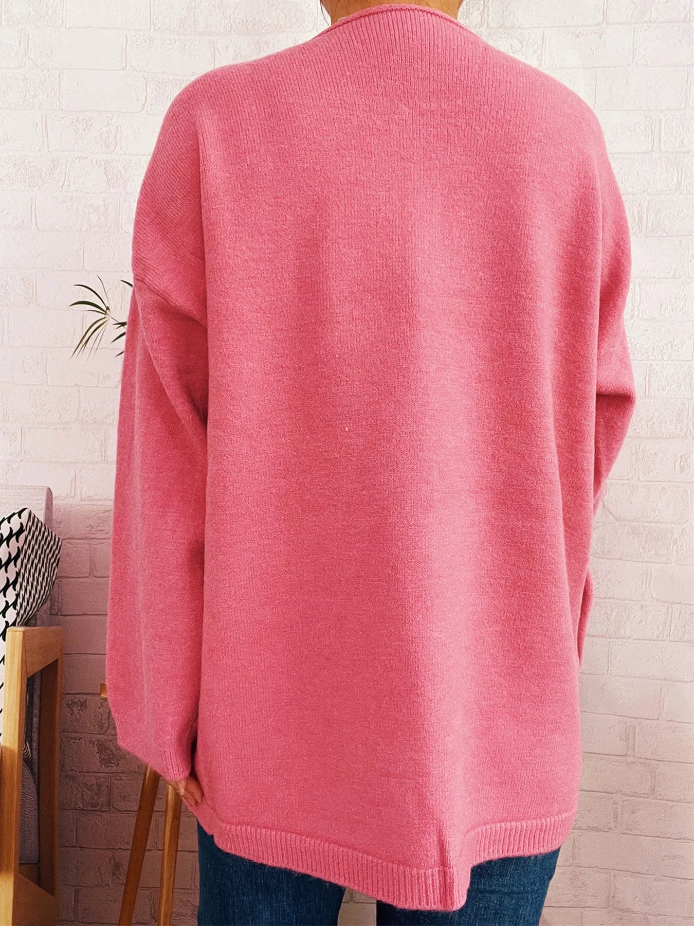 Pink back view of one-button front drop-shoulder cardigan with ribbed hem