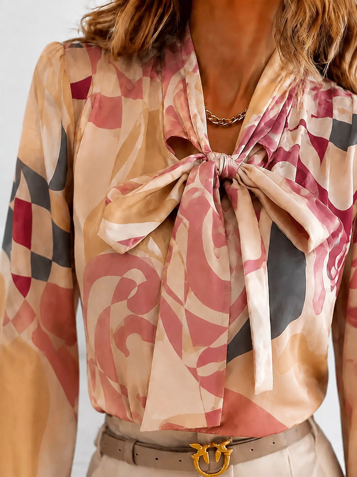 Printed bow-tie neck long-sleeve blouse with tied neckline and pink abstract print