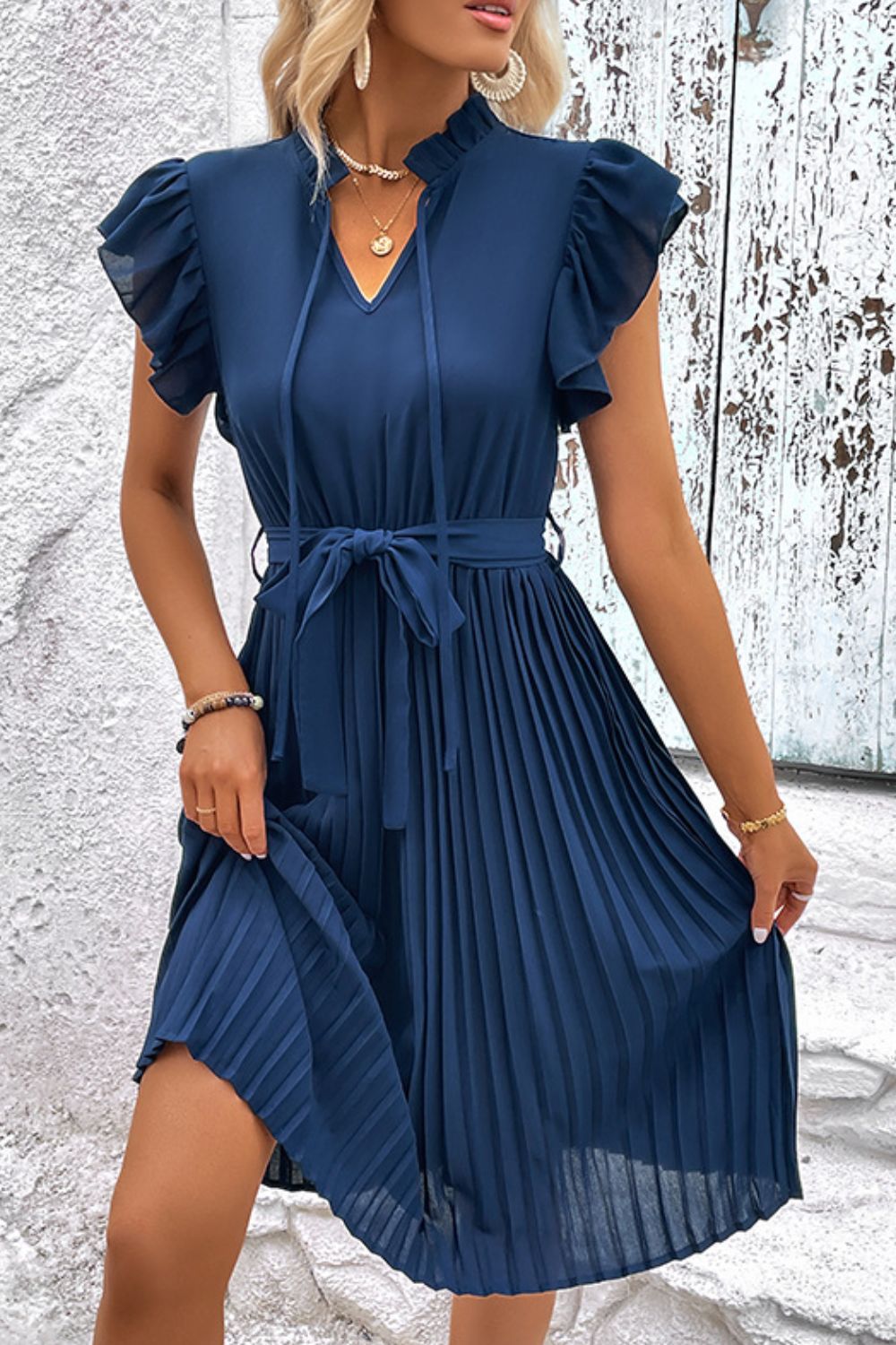 Deep teal pleated midi dress with tie neck, ruffled sleeves, and waist belt