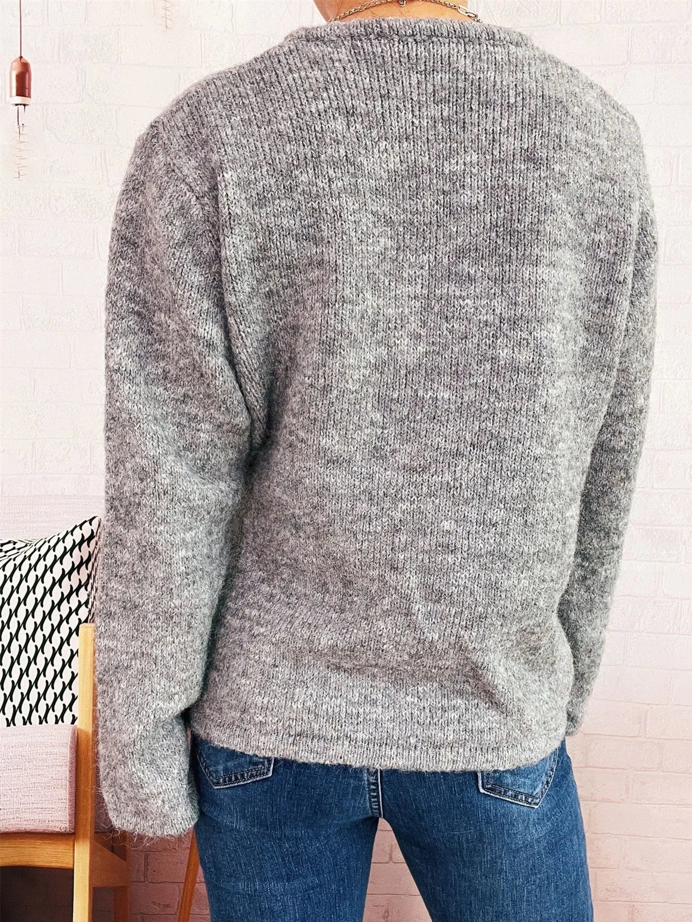 Gray knit sweater with crew neck and long sleeves, back view