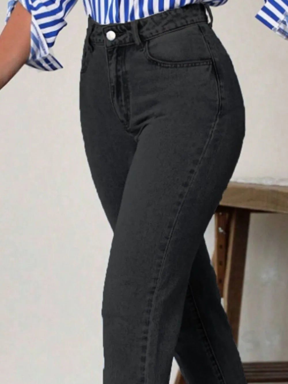 Black high-waist jeans with pockets, button waistband, close-up of hip area