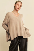 Tan ribbed V-neck sweater with side slits and bell sleeves