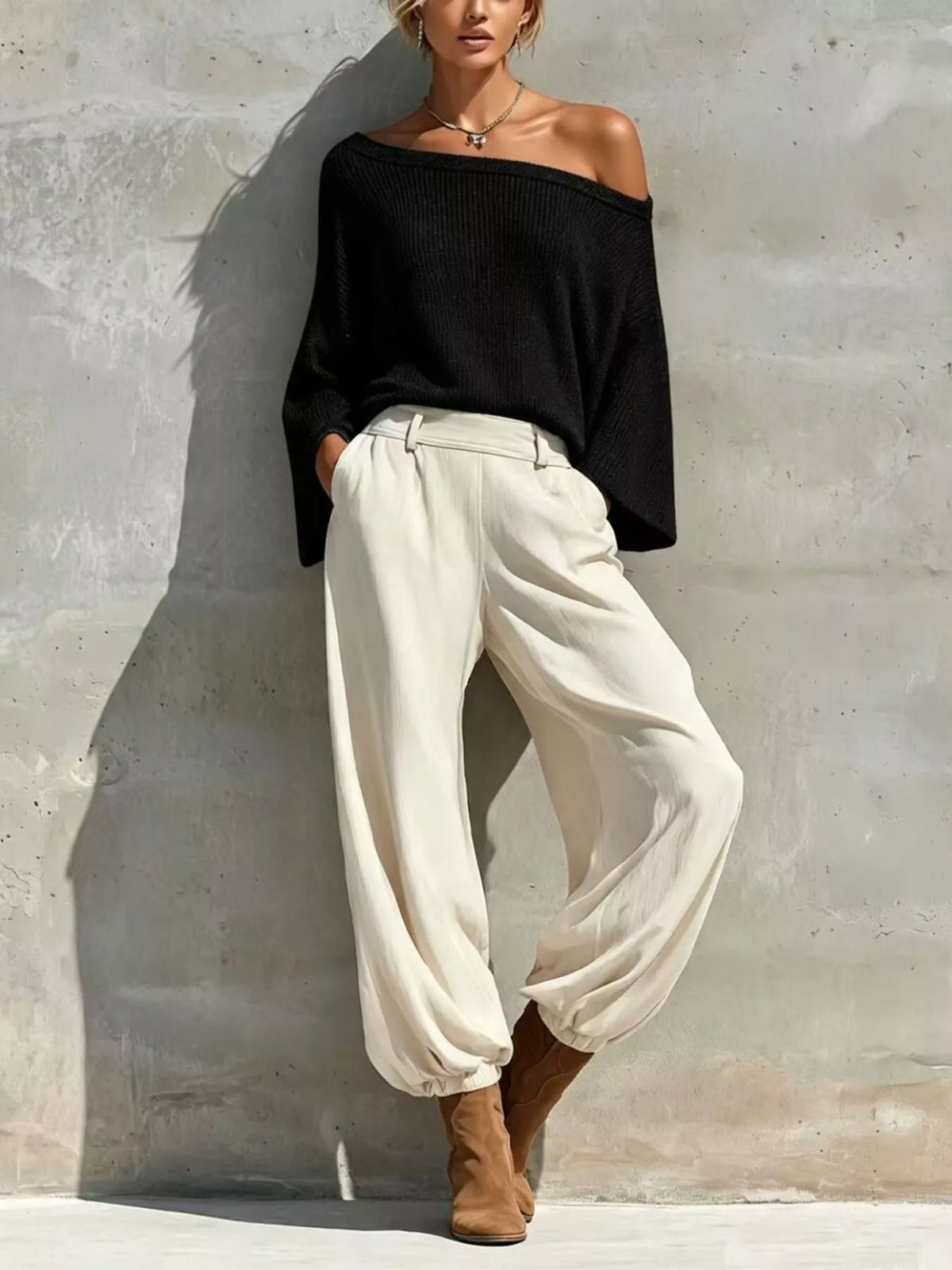 Black off-shoulder knit top with high-waisted white jogger pants and elastic cuffs