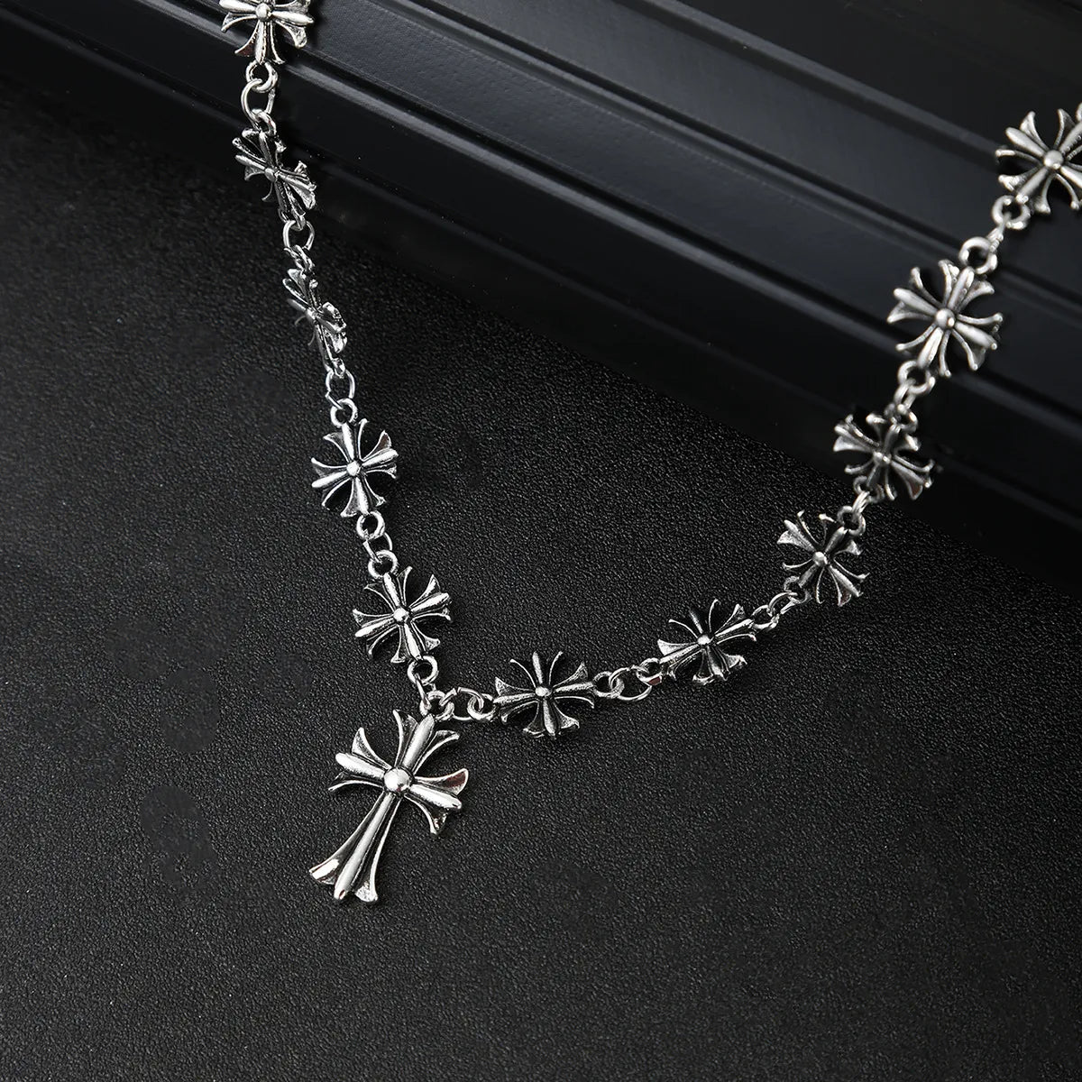 Silver cross pendant alloy necklace close-up of starburst and cross charm links