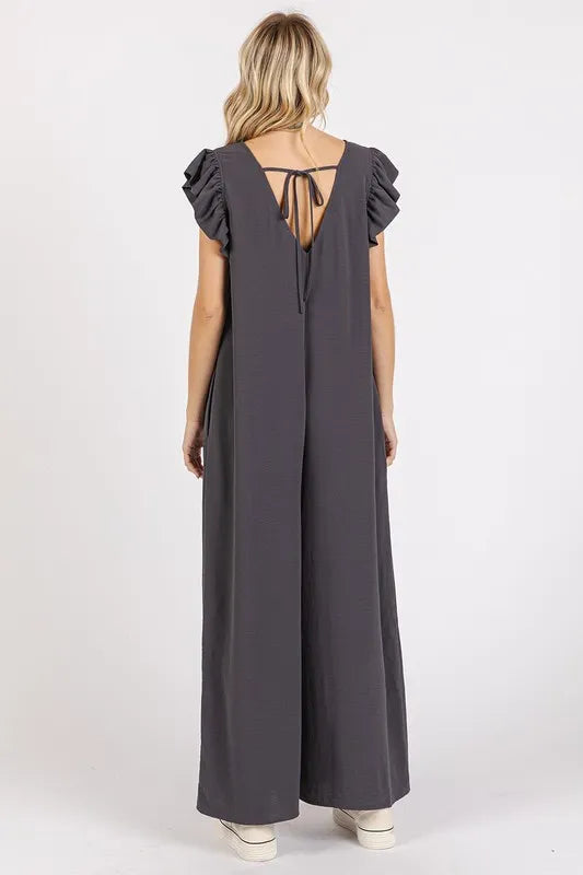 Back of charcoal v-neck ruffled cap sleeve wide-leg jumpsuit with tie keyhole
