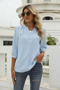 Light blue Swiss-dot blouse with notched V-neck, 3/4 sleeves, and button placket