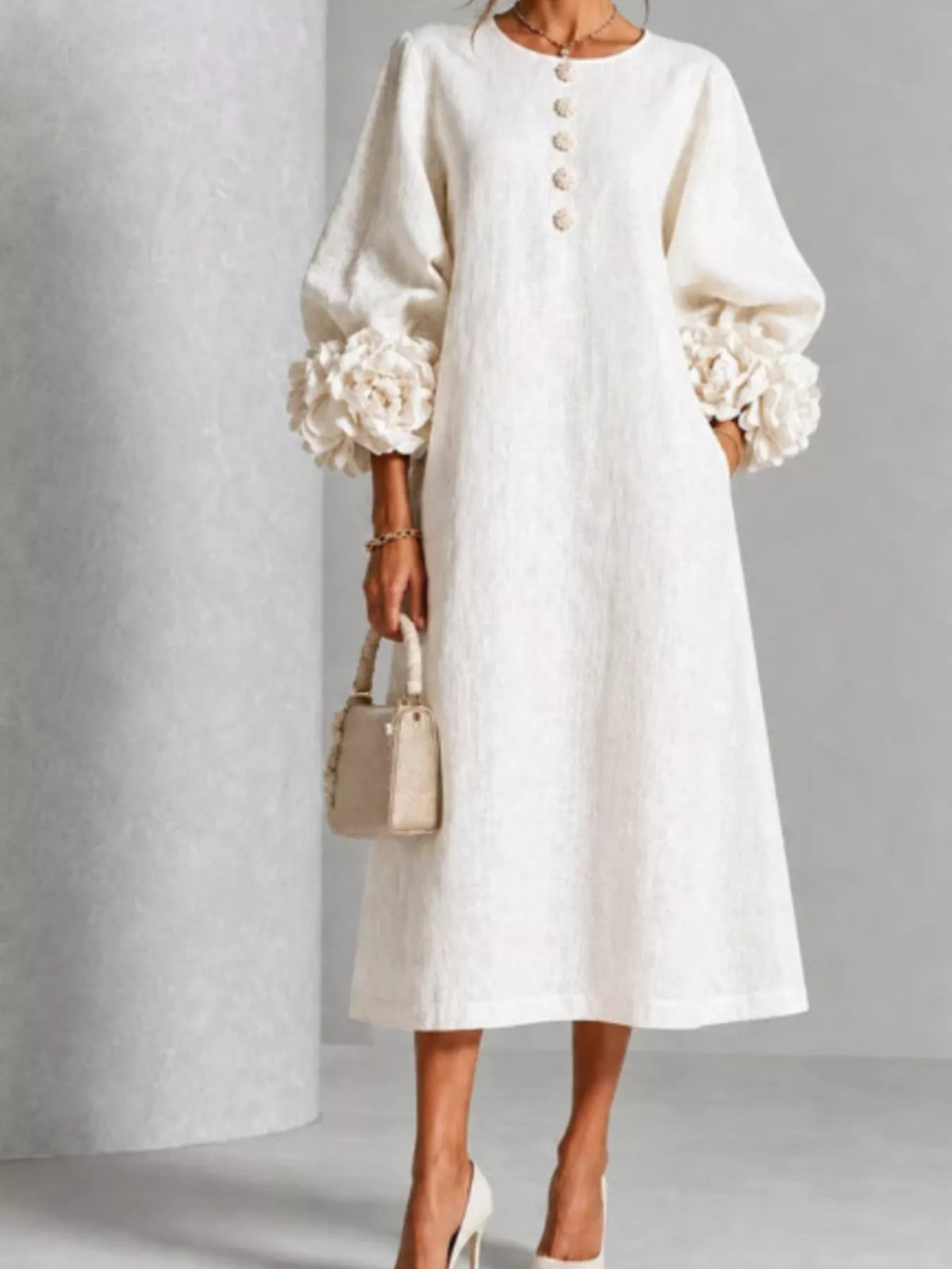White midi dress with round neck and button front, puff sleeves with 3D floral cuffs