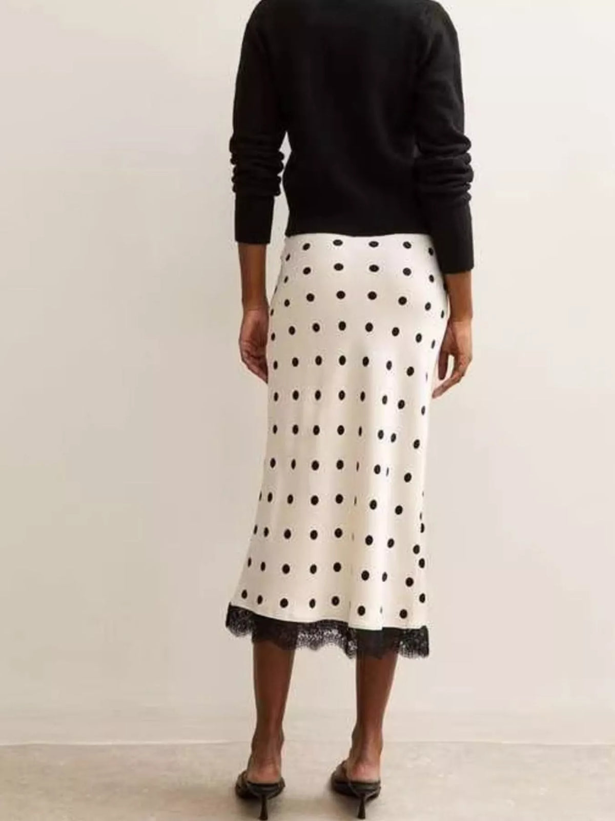 White midi skirt with black polka dots and lace-trimmed bottom hem
