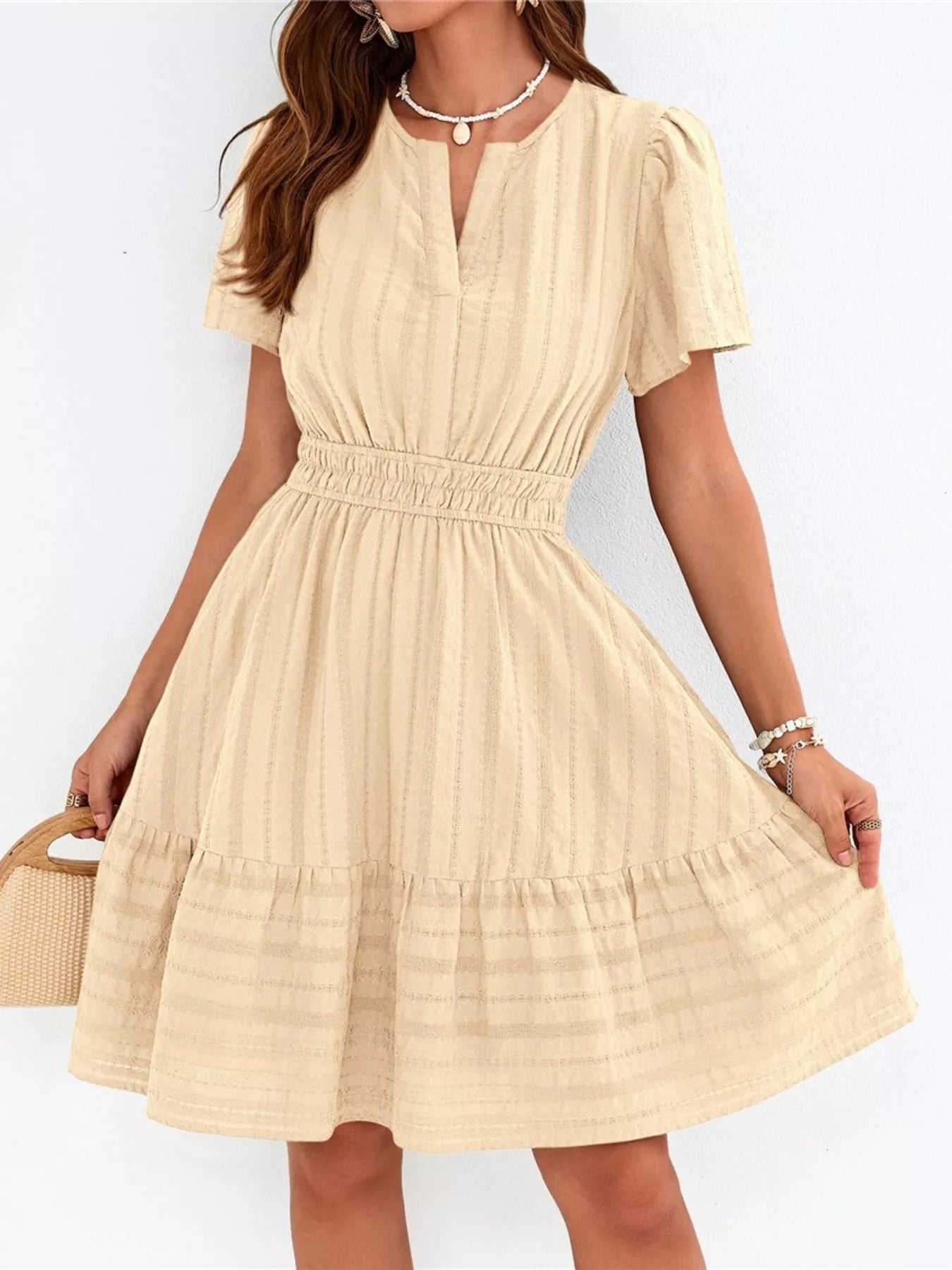 Cream short-sleeve tiered dress with smocked waist and V-neck