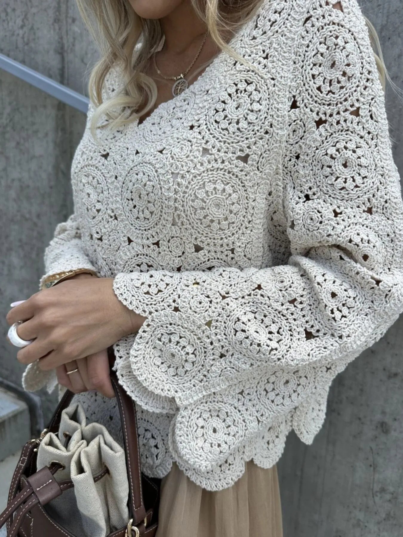 White crochet lace knit V-neck top with long bell sleeves and circular motifs