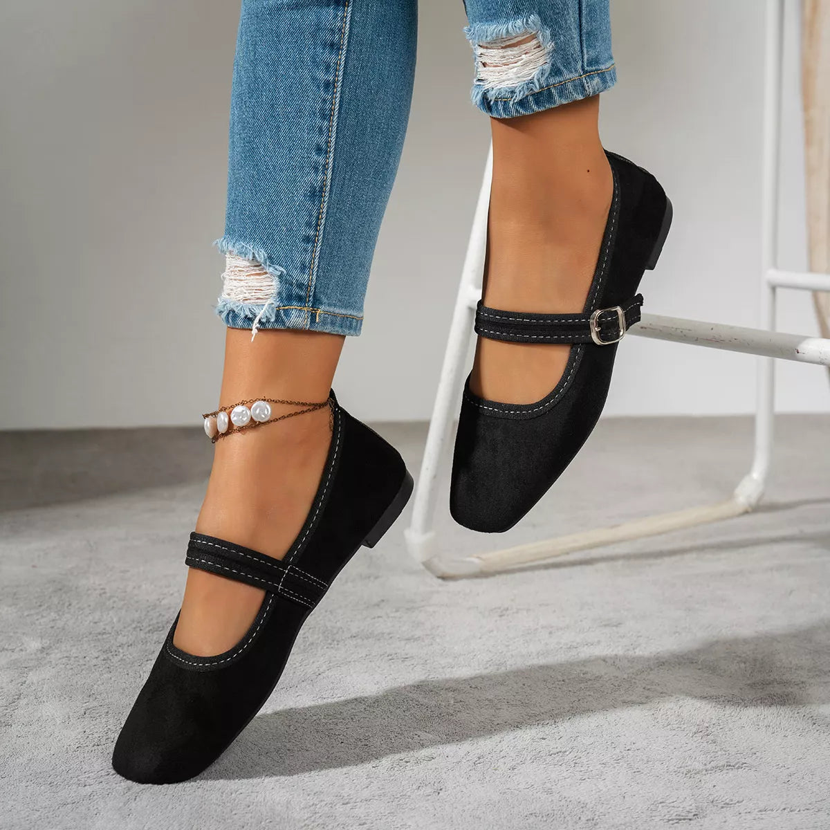 Black suede square-toe slip-on flats with ankle strap and metal buckle