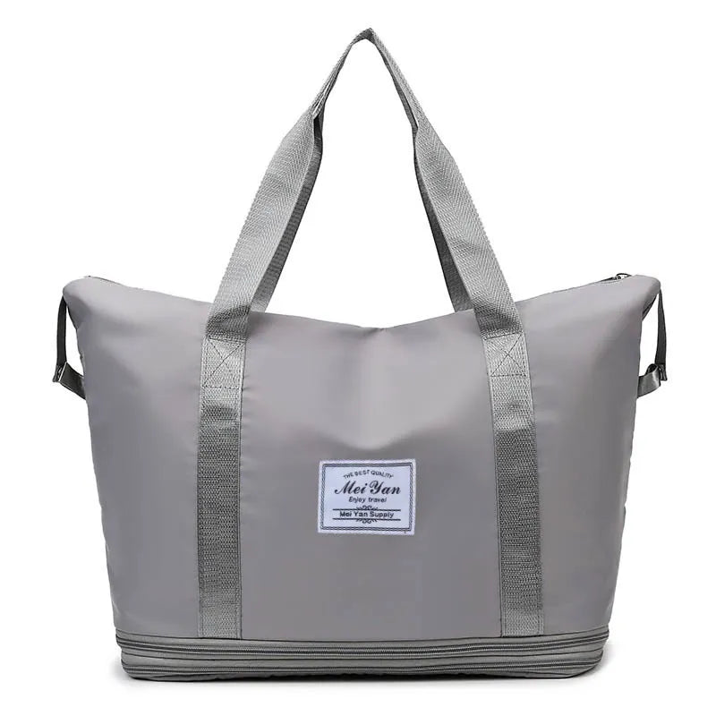 Gray large duffle bag with two top handles, side straps, and front logo patch