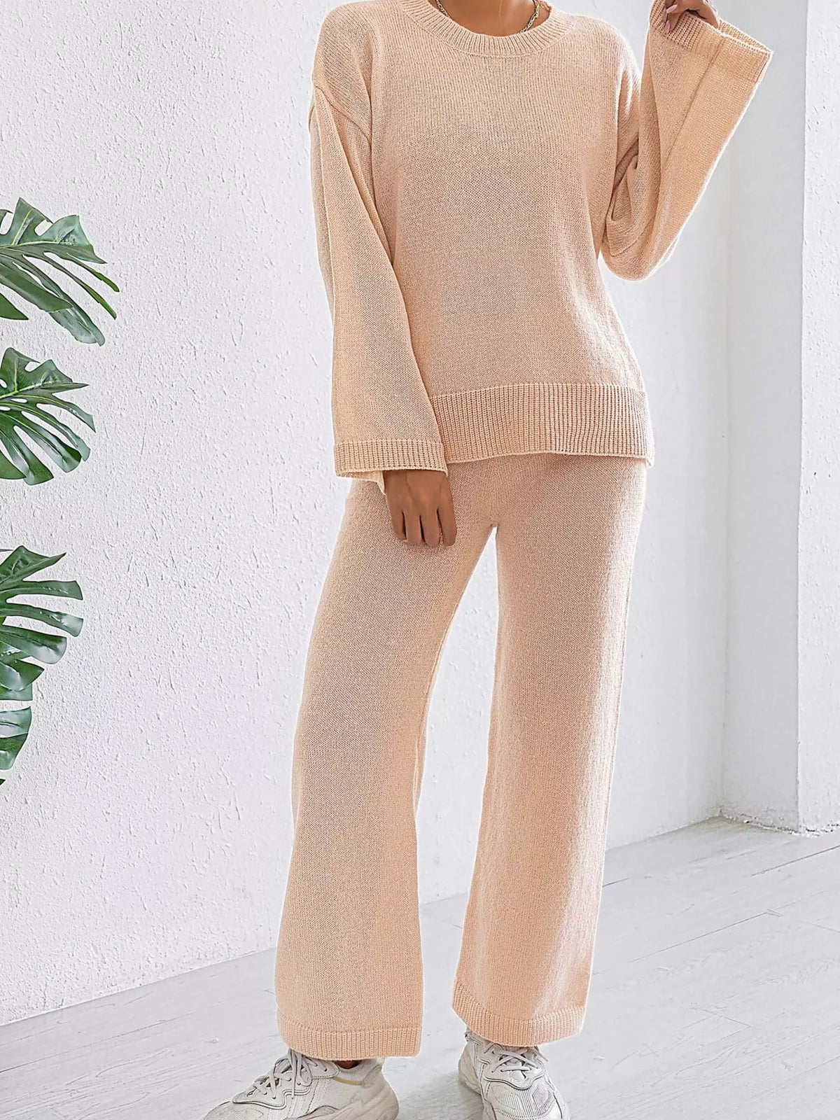 Apricot knit sweater and pants set with long sleeves and ribbed hem, relaxed wide-leg fit.