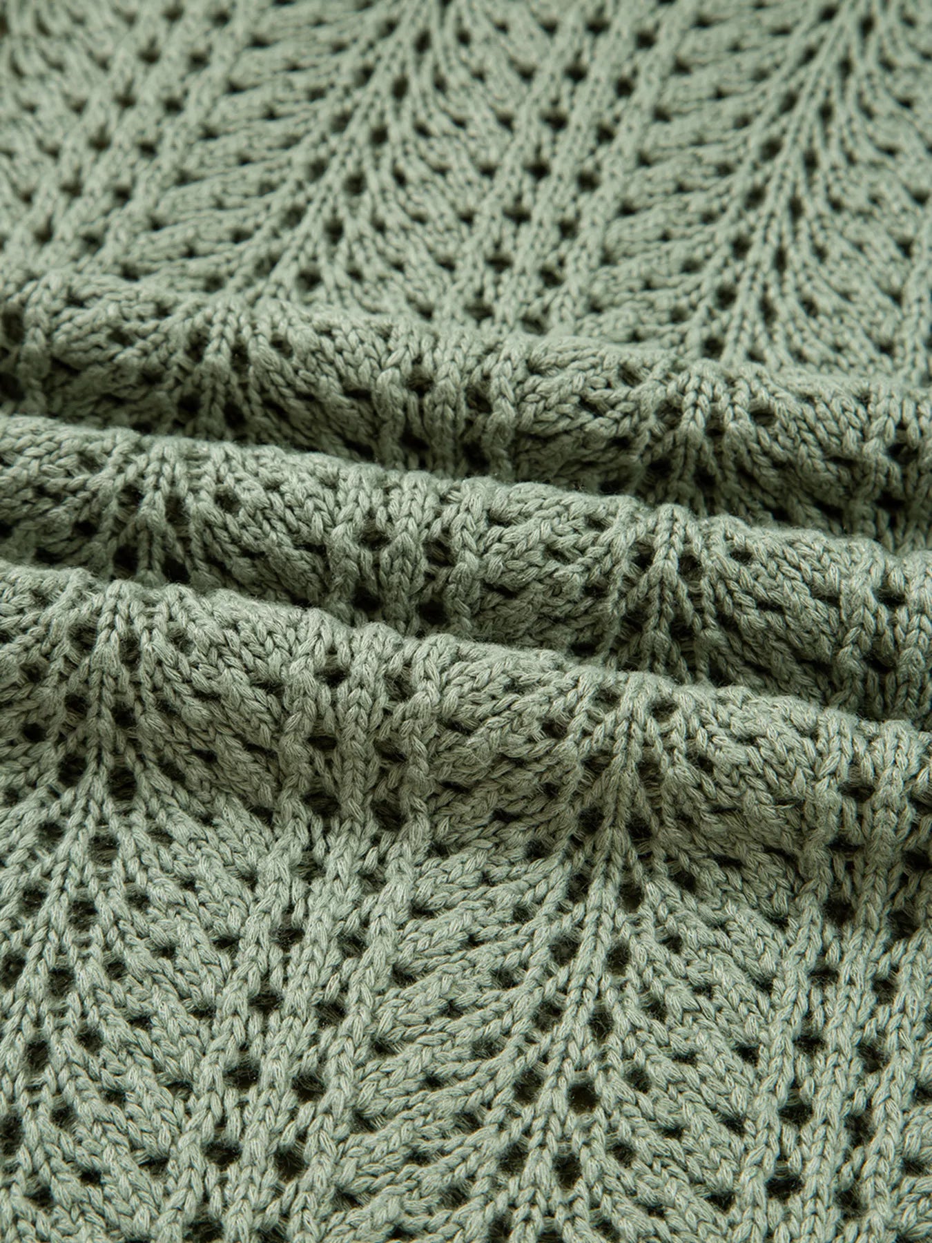 Sage eyelet knit cardigan cuff and ribbed trim with textured openwork pattern.