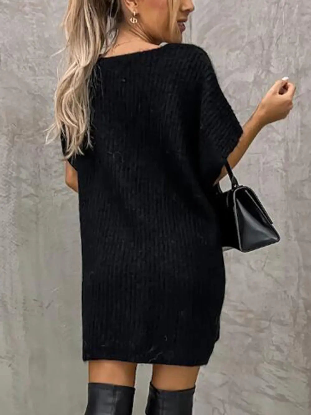 Black short-sleeve knit sweater from the back, relaxed tunic length.