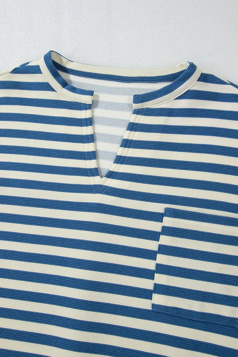 Blue and white striped V-neck button placket detail