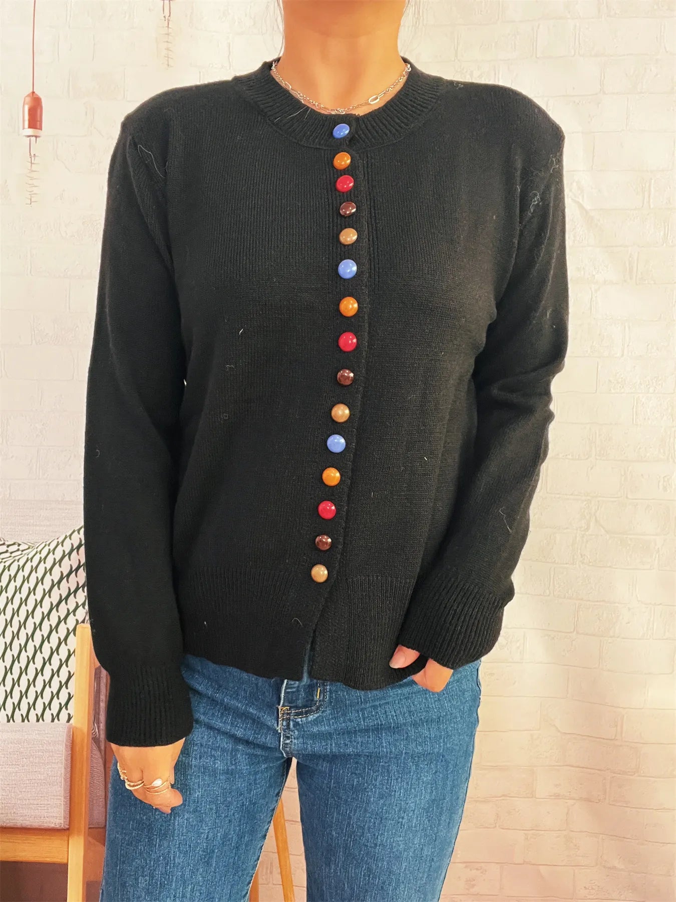 Black button-front cardigan with colorful detail buttons down center, long sleeves