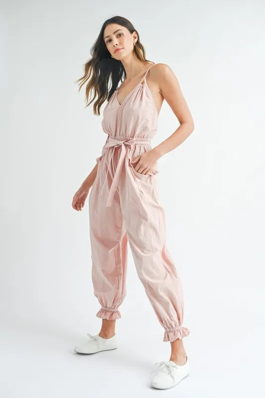 Pink spaghetti strap belted jumpsuit with loose fit and gathered ankle cuffs
