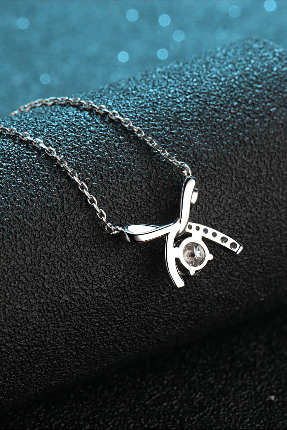 Moissanite sterling silver necklace with bow pendant and small round center gemstone
