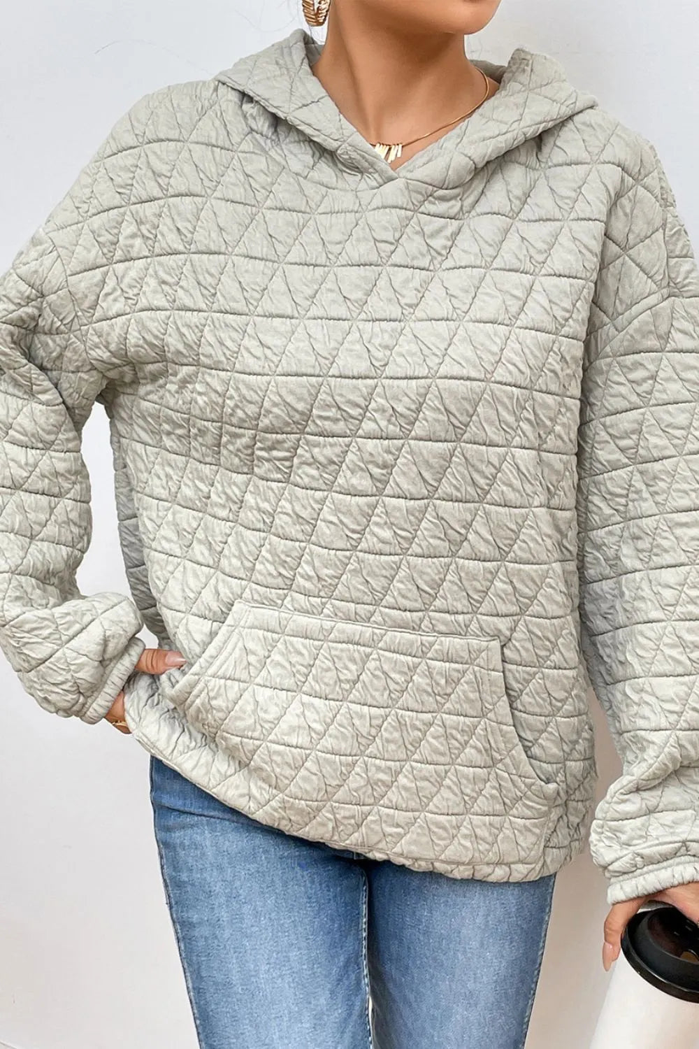 Light gray quilted long-sleeve hoodie with hood and front pocket