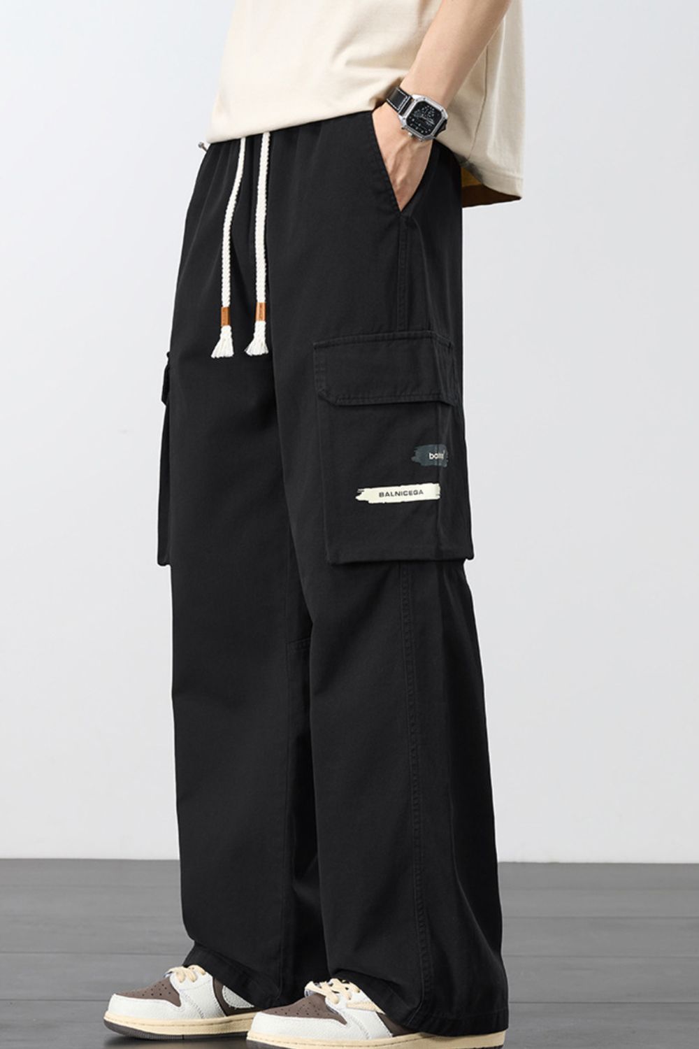 Men's loose cargo pants in black with drawstring and side cargo flap pocket