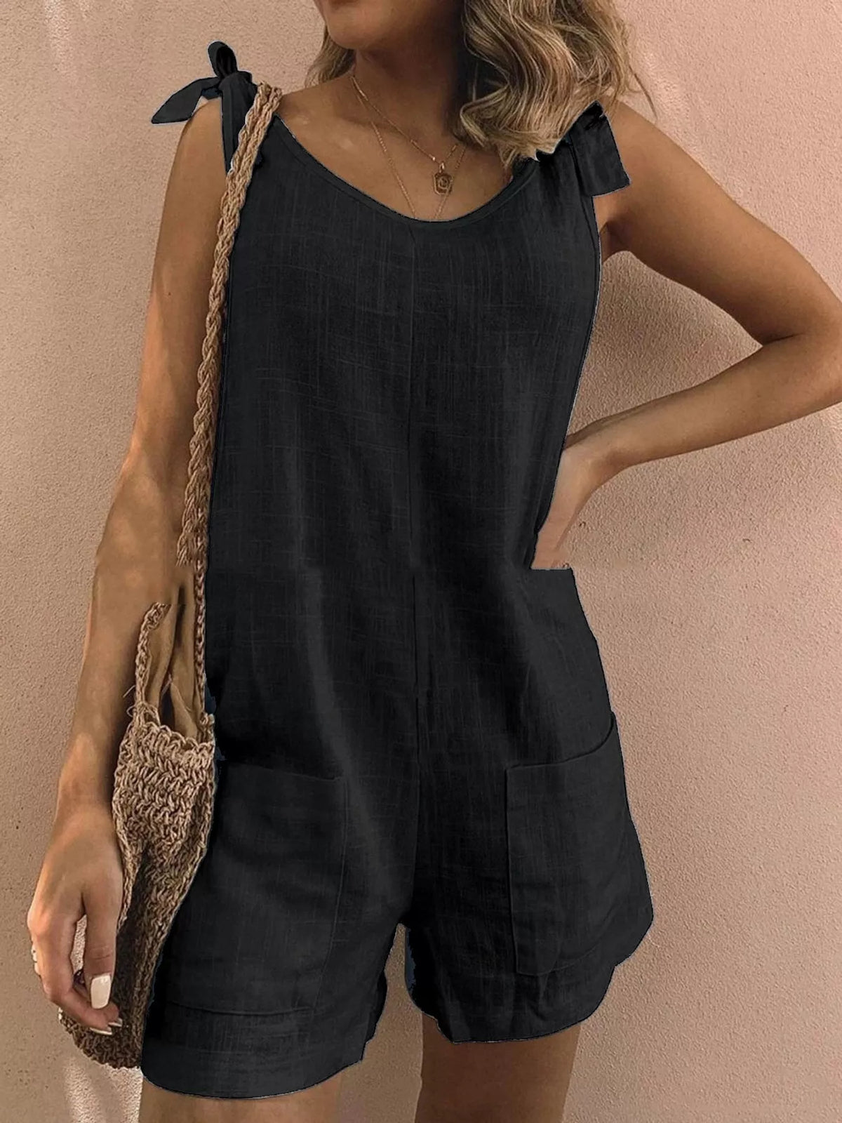 Black tie-shoulder bow romper with front pockets and relaxed short legs