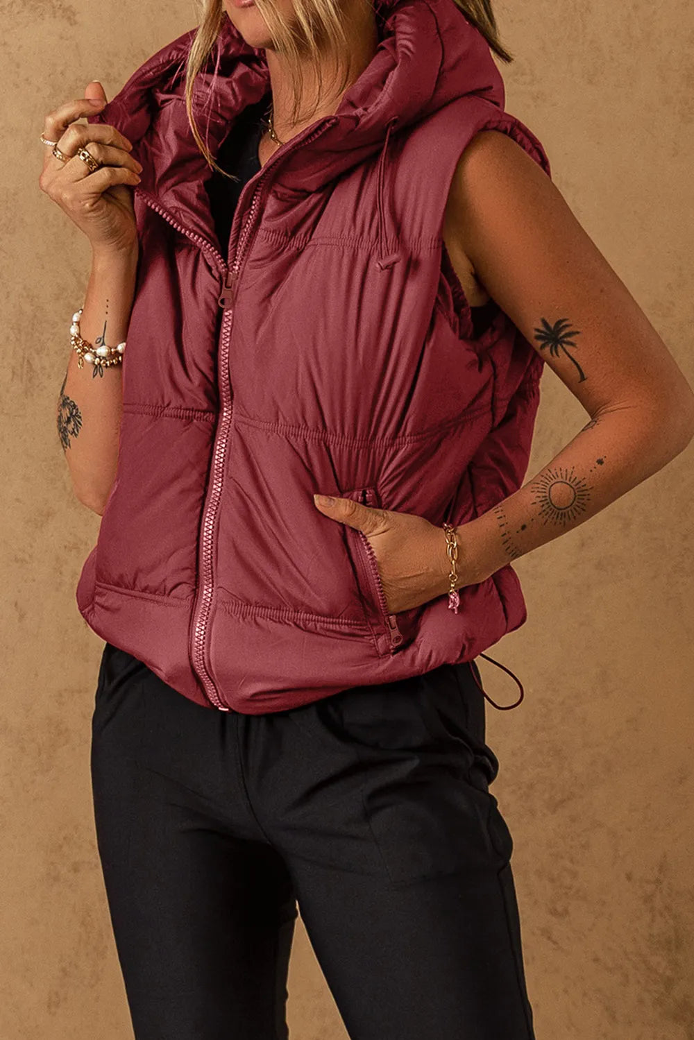 Burgundy hooded zip-up puffer vest coat with angled zip pockets and drawstring waist